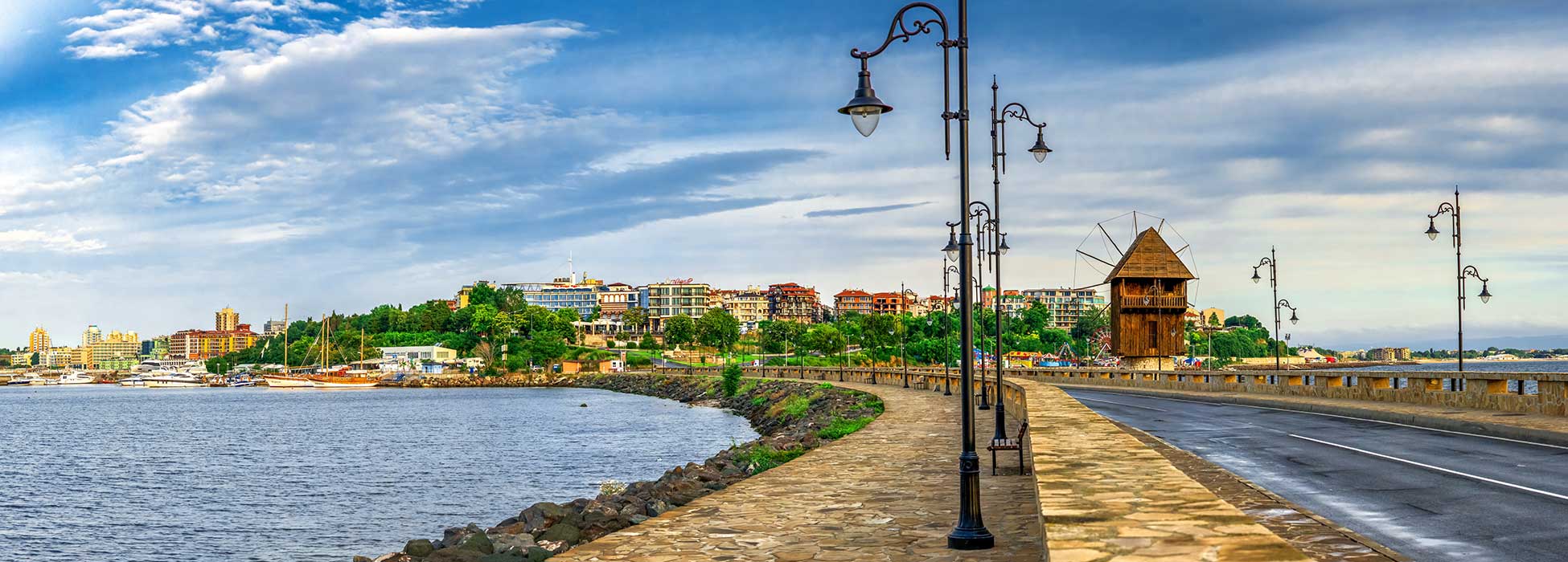 Paseo marítimo de Nesebar, Bulgaria, con un molino de viento de madera y el Mar Negro.